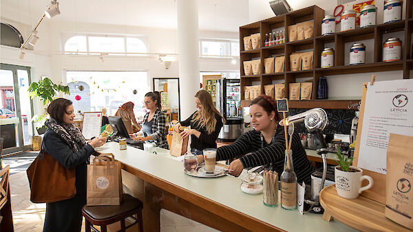 Photo of the shop counter at Die Kümmerei with staff and customers